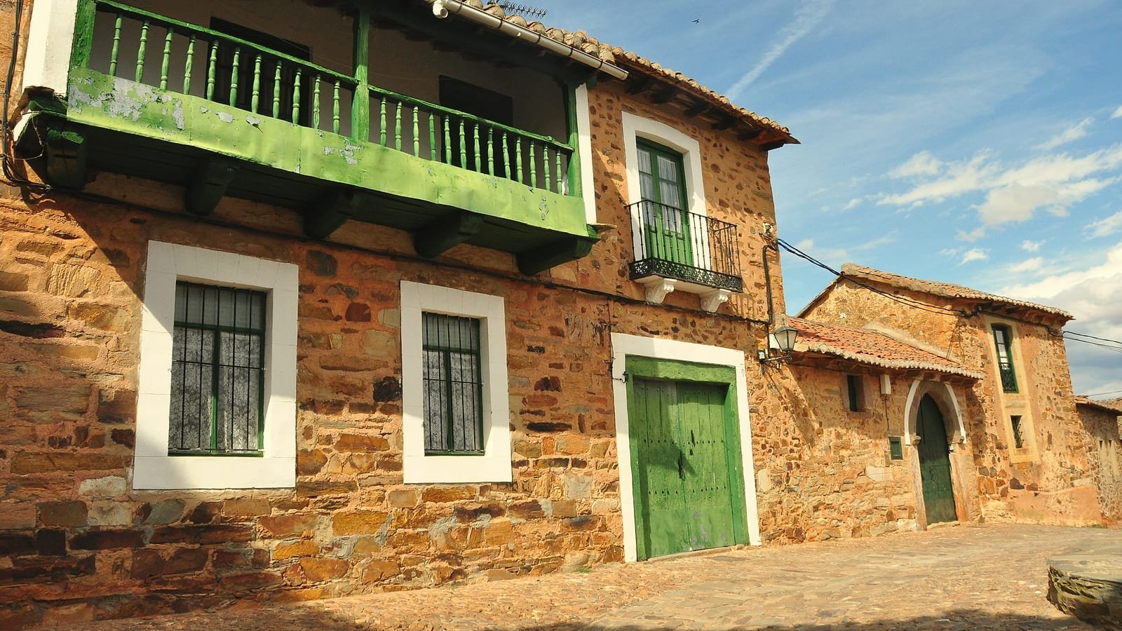 Casas de pedra con balcóns verdes en Castrillo de los Polvazares, aldea maragata do Camiño Francés